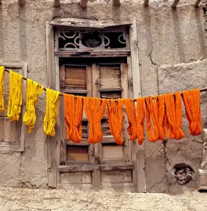 Dyed Prints: Afghanistan, Ghazni. Colorful woolen yarn dries on wooden poles in Ghazni in Afghanistan