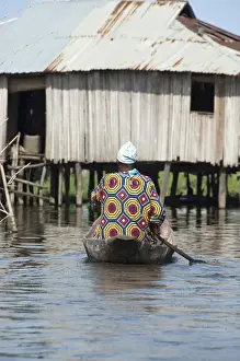 Paddle Prints: Africa, Benin, Ganvie. Tofinu villager in dugout canoe on the waters of Lake Nokoue