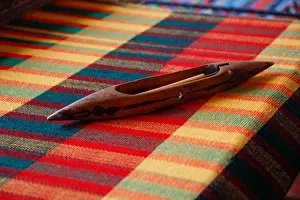 Textiles Prints: Africa, Egypt. Weaving shuttle lying on colorful woven Egyptian fabric
