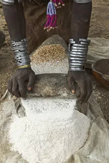 Ethiopia Gallery: Africa, Ethiopia, Southern Omo, Karo Tribe. Woman grinding grain into flour with stone