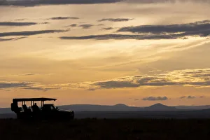 Africa, Kenya, Northern Serengeti Plains, Msai Mara. Mara sunrise with safari jeep