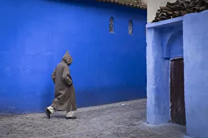 Djellaba Prints: Africa, Morocco. A man walks through an alley in the blue-washed city of Chefchaouen