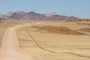 Images Dated 28th August 2014: Africa, Namibia, Namib Desert. Long road and fence in desert