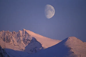Alaska, Anchorage Full moon rises behind Chugach Mountains Range