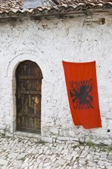 Images Dated 11th July 2006: The Albanian flag, red with black double headed eagle, against a white washed stone wall