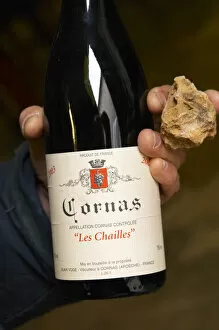 Images Dated 16th April 2005: Alberic Mazoyer showing in his hand a bottle of Cornas les Chailles and a stone