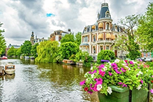 Houseboat Prints: Amsterdam, Netherlands. Wide angle view of historic houses on tree and flower lined canal