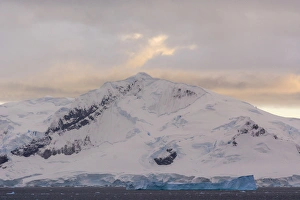 Images Dated 19th February 2014: Antarctica. Antarctic Peninsula. Paradise Harbor. Snowy mountains and clouds at sunrise