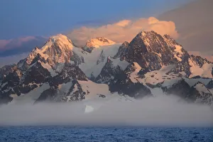 Images Dated 13th August 2020: Antarctica, South Georgia Island, Coopers Bay. Iceberg and mountains at sunrise