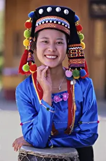 Yunnan Prints: Asia, China, Yunnan Province. Young De ang minority woman in traditional costume with drum