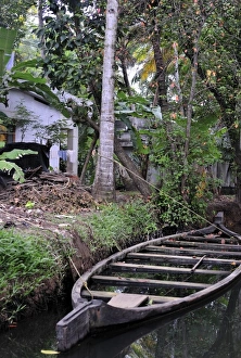 Images Dated 31st March 2007: Asia, India, Kerala (Backwaters). A flooded boat rests alongside a Kerala Backwaters canal