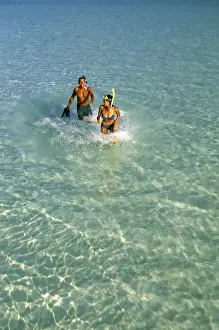 Snorkel Prints: Asia, Maldives. Couple running through waves with diving gear (MR)