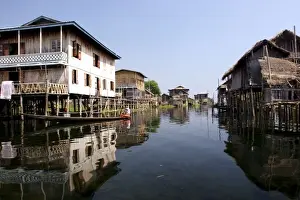 Dry Season Prints: Asia, Myanmar, Inle Lake, canoe paddling through Intha stilt village in dry season