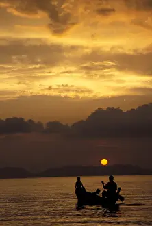 Asia, Thailand, Phang Nga Bay. Father and boys rowing at sunset near Hat Khlang Muang