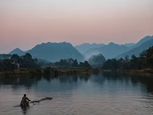 Bamboo Prints: Asia, Vietnam, Pu Luong Nature Reserve. Lone man takes simple raft out onto river