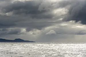 Australia Prints: Australia, Tasmania, Tasman Sea. Dramatic line of sun on horizon through storm clouds