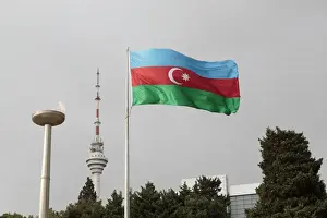 Baku Prints: Azerbaijan, Baku. An Azerbaijan flag waves near a memorial flame and the Baku TV tower