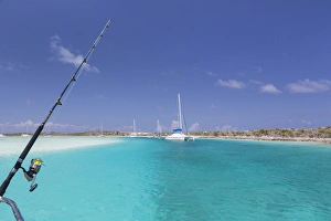 Bahamas, Exuma Island, Cays Land and Sea Park. Moored sailboats and fishing rod. Credit as