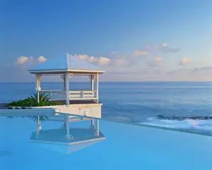 Bahamas, Long Island, Gazebo reflecting on pool with sea in background