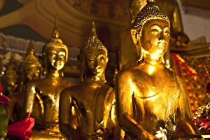Wat Phra Kaeo Prints: Bangkok, Thailand - Row of ornate, golden Buddhist statues in a temple