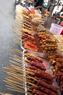 Boiling Prints: Bangkok, Thailand - Tilted view of a street vendor selling various Thai foods on wood skewers