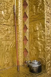 Bhutan, Punakha Dzong. Old tea pot and staff outside the gilded temple walls