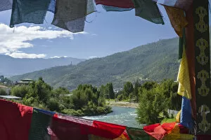 Bhutan, Punakha. Prayer flags line the cantilever bridge over the Mo Cchu river at