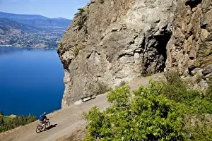 Recreation Prints: Biker rides on the Kettle Valley Railway bike path above Okanagan Lake near Penticton