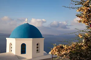 Steeple Prints: Blue domed Greek Orthodox church with bougainvillea flowers in Oia, Santorini, Greece
