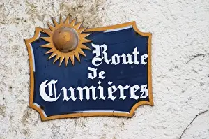 Roadsign Prints: A blue street sign on a white wall in the village that indicates the road to