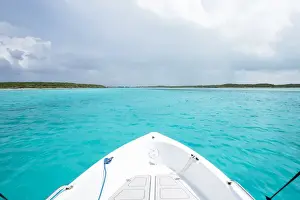 Boating Prints: A boat drives through clear aquamarine waters near Staniel Cay, Exuma, Bahamas