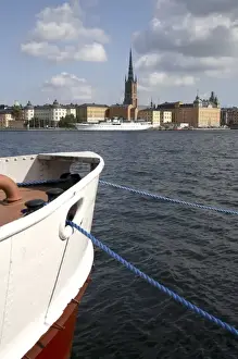 Swedish Prints: A boat in Sodermalm Island dock with Riddarholmen Island and the black spire of Riddarholmskyrkan