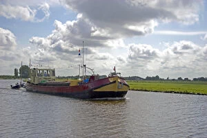 Boat traveling on a canal east of Leiden in the province of South Holland, Netherlands