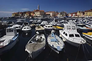 Boats docked in harbor in front of distant Cathedral of St. Euphemia, Rovigno, Croatia