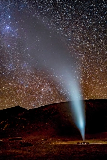 Volcanic Prints: Bolivia. Vertical landscape view of geyser erupting in Bolivia's Sol de Manana with Milky Way behind