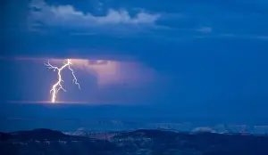 Distant Prints: A bolt of lightning strikes the Utah desert as a rain storm moves across the landscape
