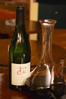Bottle on a table with wine glasses and decanter in the wine bar Le Cafe du Passage in Paris