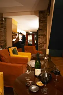 Coffee Prints: Bottle on a table with wine glasses and decanter in the wine bar Le Cafe du Passage in Paris