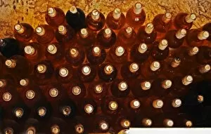 Bottles of sauternes stacked hig, shining golden in the cellar light Chateau de Cerons