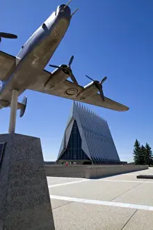 College Prints: Bronze sculpure of vintage WW11 aircraft in front of the Cadet Chapel at the Air