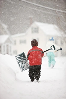 Images Dated 18th January 2009: A brother and sister shovel snow during a snowstorm in Portsmouth, New Hampshire