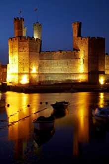 Caernarfon Castle reflected in River Seiont at dusk, Caernarfon, Wales