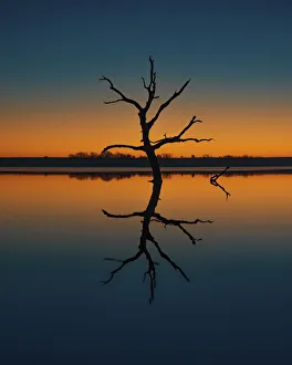 Flint Hills Prints: Calm day at a Kansas lake creating reflections of the illuminating blue and orange sky