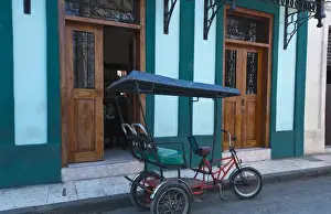 Images Dated 2029: Camaquey Cuba street scene of old bike carriage on street and buildings