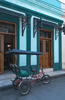 Images Dated 2029: Camaquey Cuba street scene of old bike carriage on street and buildings
