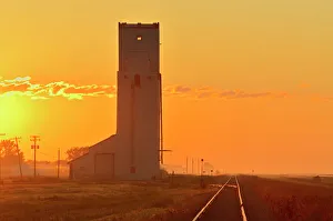 Manitoba Prints: Canada, Manitoba, Culross. Grain elevator and railroad tracks at sunrise. Credit as