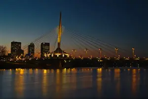 Red River Prints: Canada, Manitoba, Winnipeg. Esplanade Riel bridge and city skyline reflected in Red River at dusk