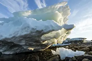 Low Angle View Prints: Canada, Nunavut Territory, Melting iceberg stranded by low tide along Frozen Channel