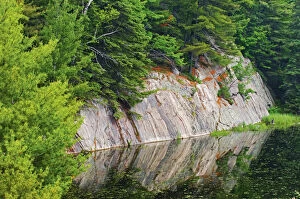Canada, Ontario, Killarney District. Granite reflected in water