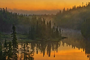 Canada Collection: Canada, Ontario, Schreiber. Sunrise fog and forest reflect in lake